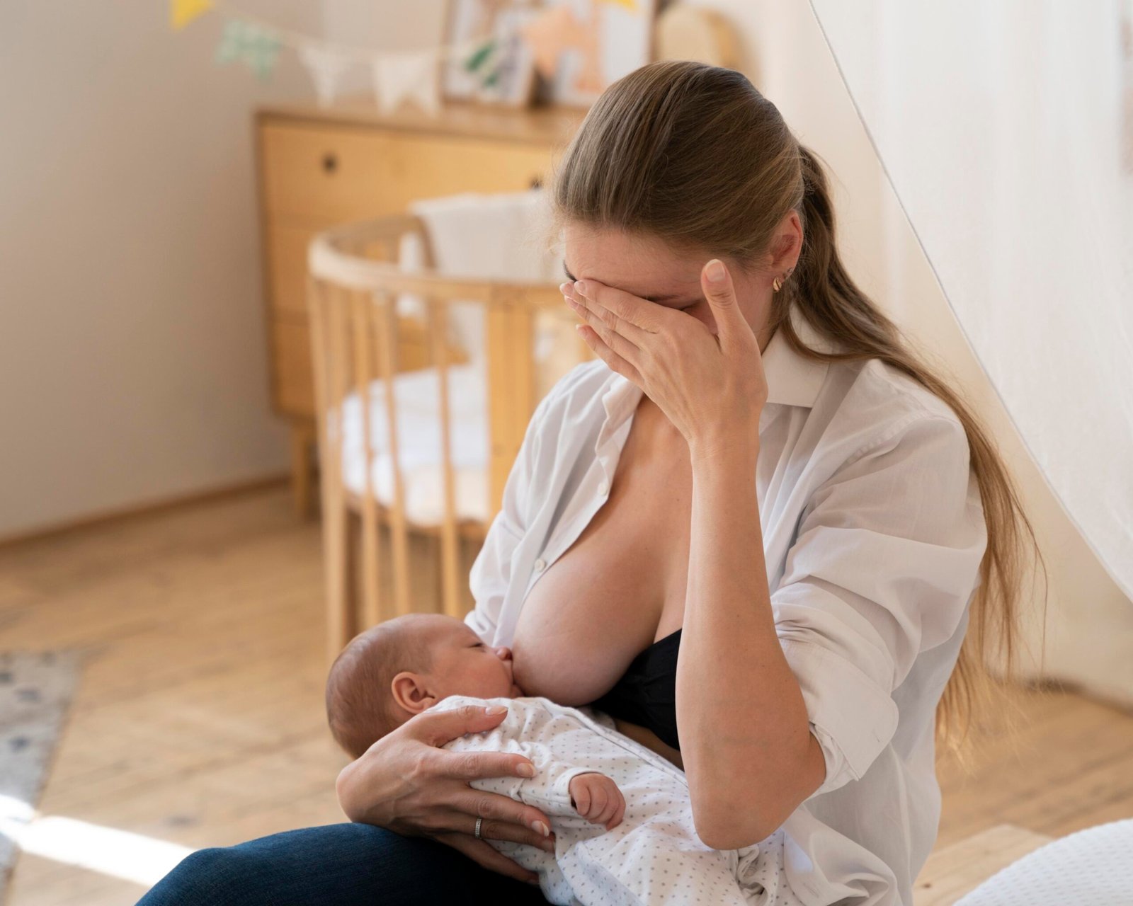 Mãe exausta amamentando o bebê, simbolizando quando o cuidado com os outros faz a mulher esquecer de si mesma